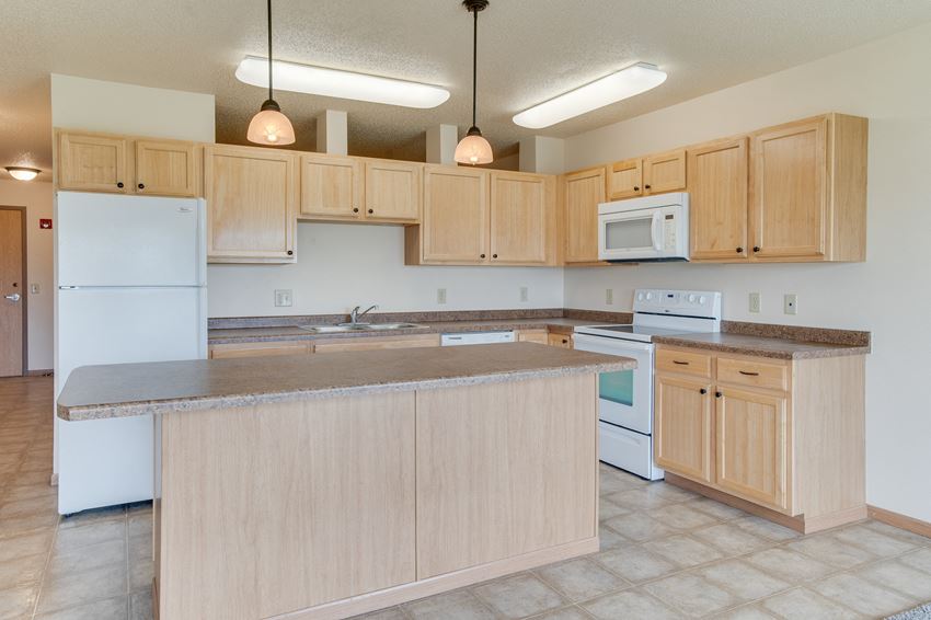 a kitchen with an island and white appliances