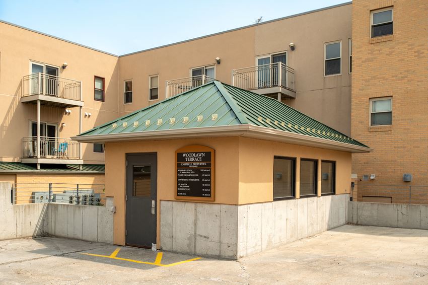 a small building with a green roof and a black door