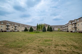 an open field with an apartment complex in the background