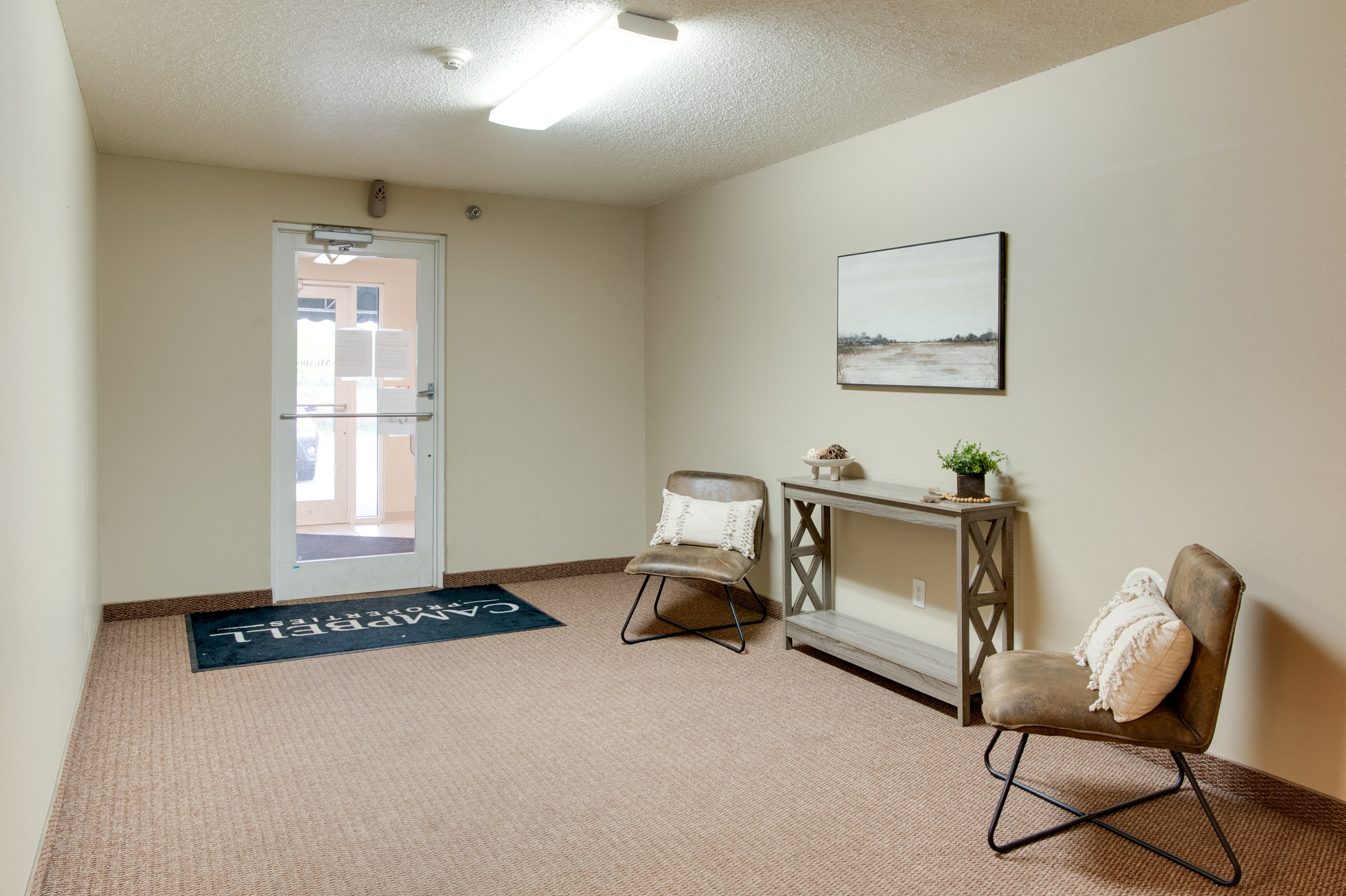 a living room with two chairs and a table and a door