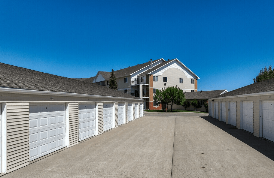 A row of white garage doors in front of a house.