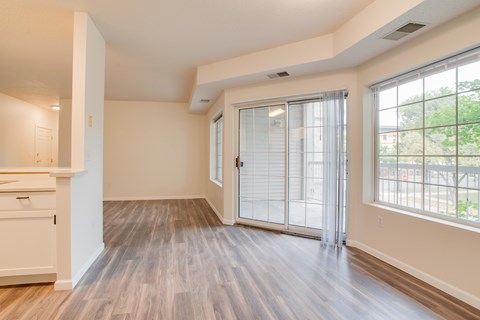 A room with a sliding glass door and wooden flooring.