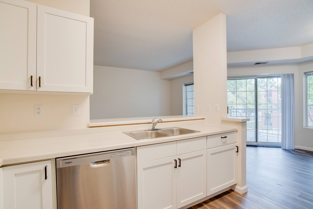 A kitchen with white cabinets and a stainless steel dishwasher.