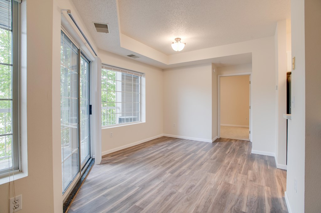 A room with a sliding glass door and a wooden floor.