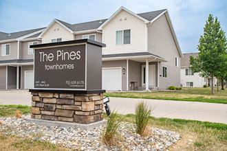 a picture of the pines townhomes sign in front of the house