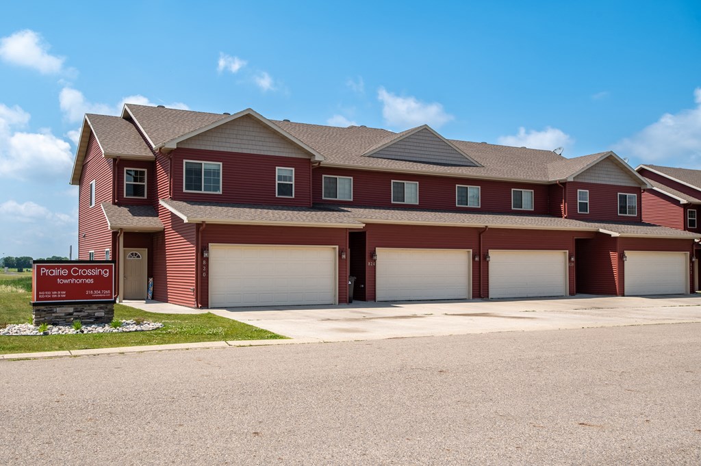 a house with two garage doors and a sign in front of it