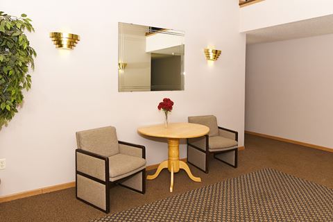 a room with a table and three chairs in front of a mirror
