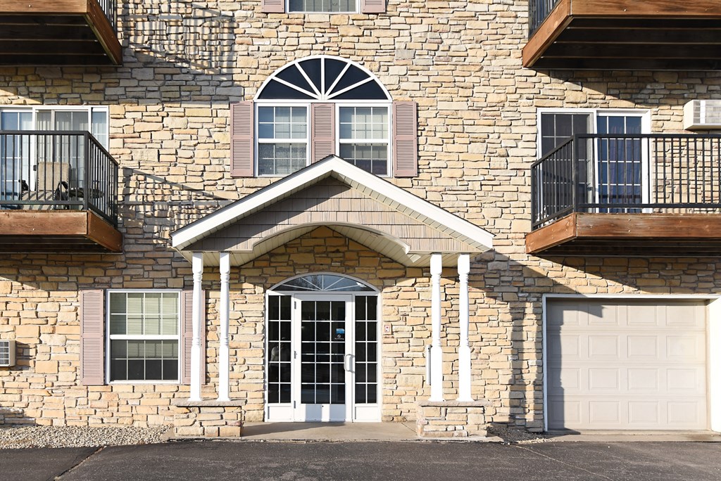 the front of a brick house with a white garage door