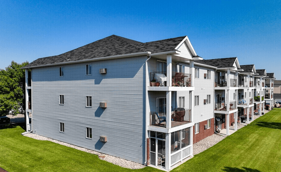 A row of townhouses with balconies and a clear blue sky above, at Royal Oaks Apartments, Fargo
