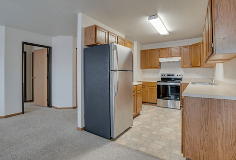 A kitchen with a refrigerator, oven, and stove.