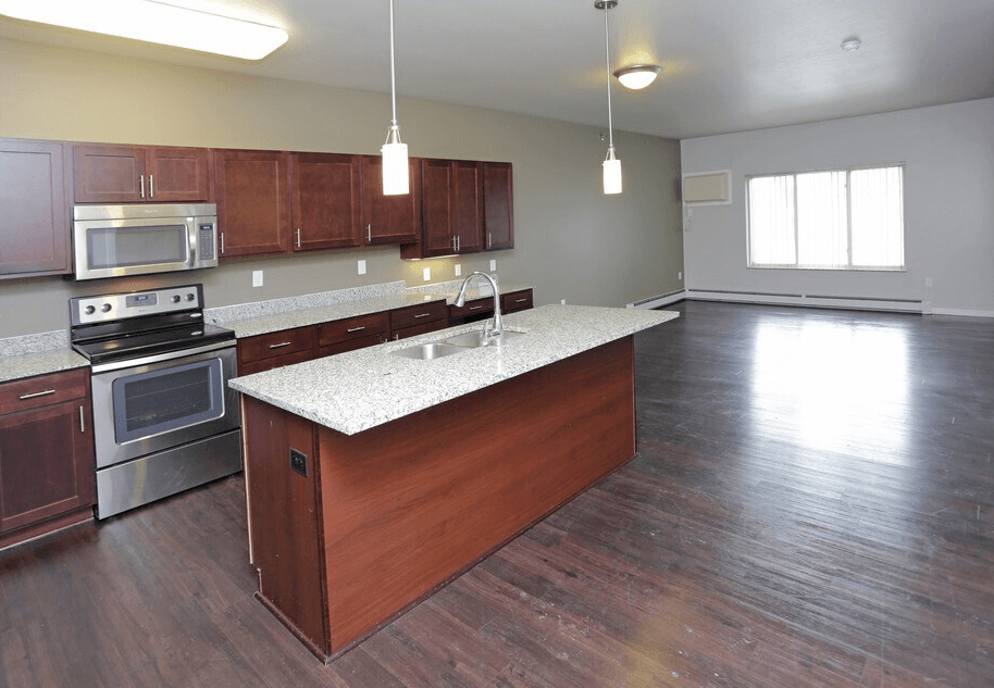 A kitchen with wooden cabinets and a stainless steel oven.