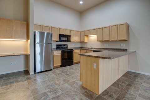 A kitchen with wooden cabinets and a granite countertop.