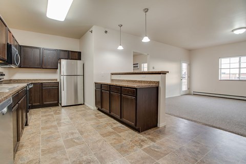 A kitchen with brown cabinets and a tiled floor.
