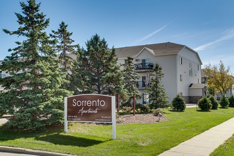 A sign for Sorrento Apartments stands in front of a building.