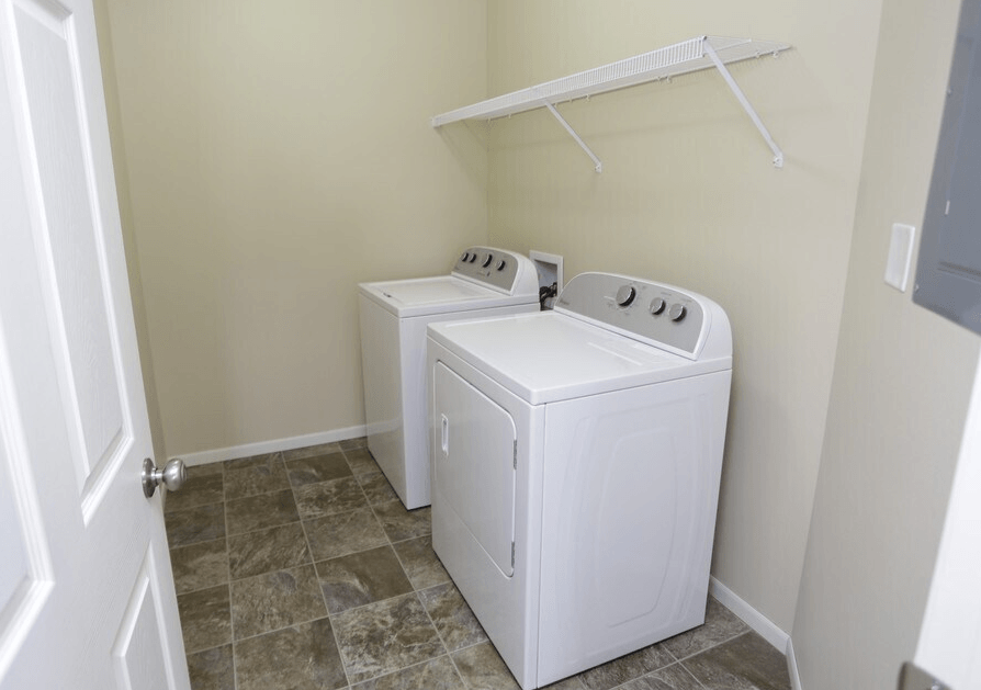 A white dryer and washer in a small laundry room. at Shadow Ridge Apartments, West Fargo, ND, 58078