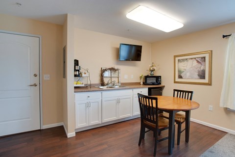 a kitchen and dining area with a table and chairs and a television