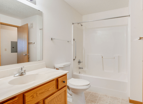 A white bathroom with a toilet, sink, and bathtub at Savanna Apartments, St Cloud, MN, 56303
