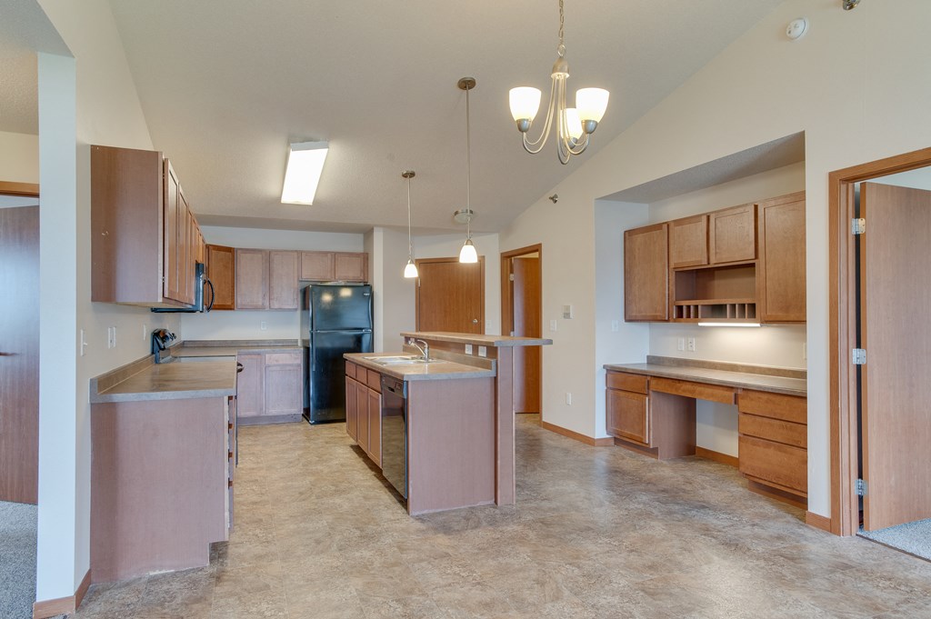 a kitchen with wooden cabinets and stainless steel appliances at Urban View Apartments, Fargo, ND
