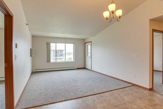 an empty living room with a window and a door