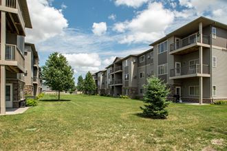 an apartment complex with a large grassy area