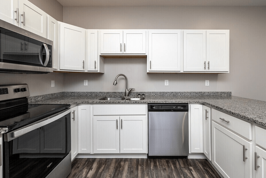 A kitchen with white cabinets and a black stove top oven. at Warehouse Apartments, North Dakota, 58102