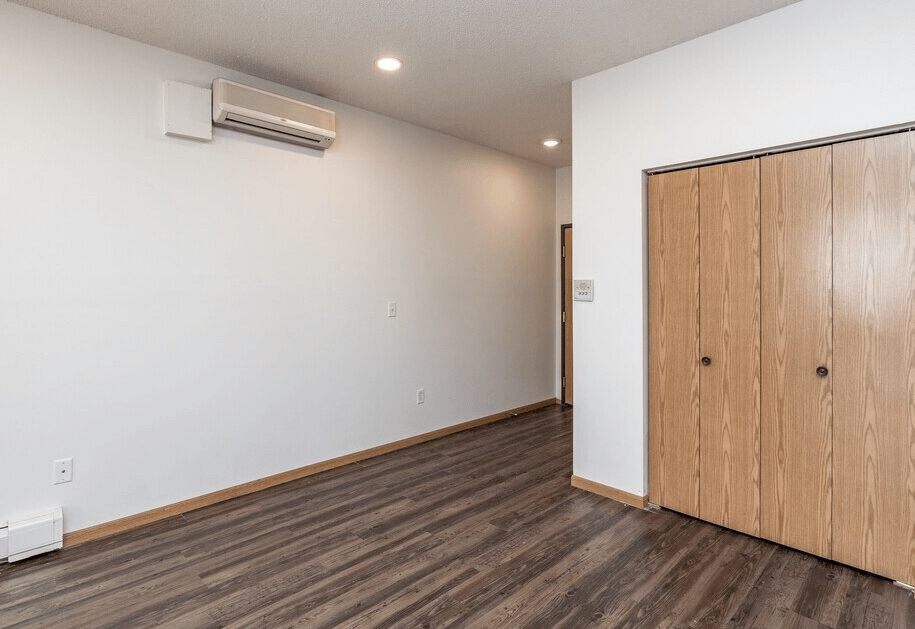 A room with a wooden floor and a wooden door.at Warehouse Apartments, Fargo, 58102