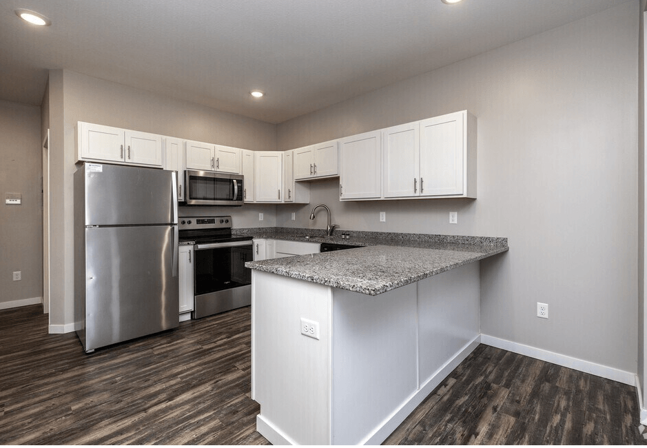 A kitchen with a granite countertop and stainless steel appliances. at Warehouse Apartments, North Dakota