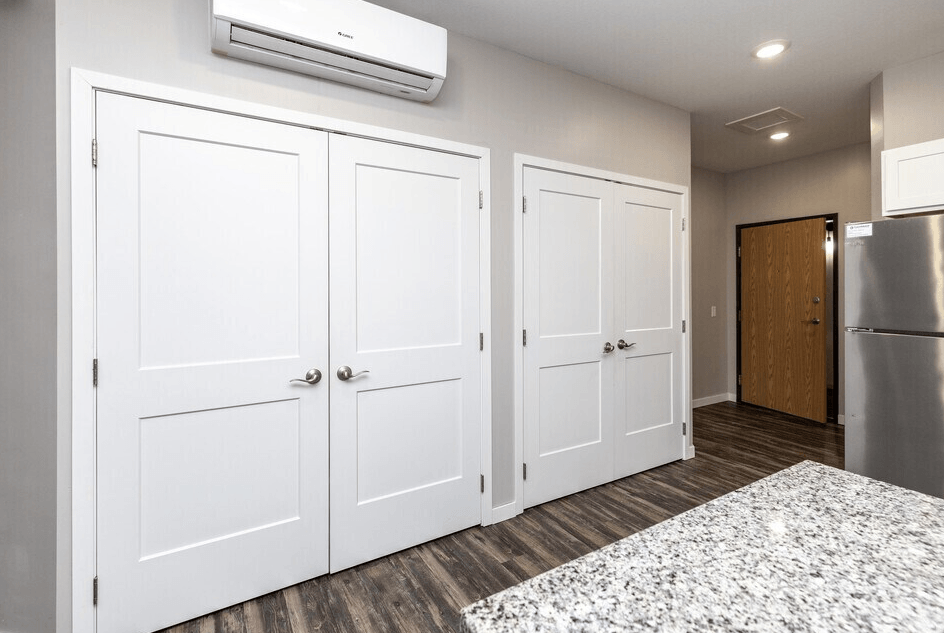 A kitchen with white cabinets and a stainless steel refrigerator. at Warehouse Apartments, Fargo
