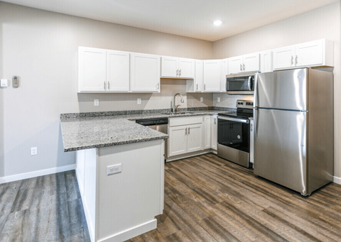A kitchen with a granite countertop and stainless steel appliances.