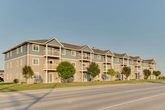a street view of an apartment complex with a clear blue sky in the background - Photo Gallery 3