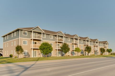 a street view of an apartment complex with a clear blue sky in the background