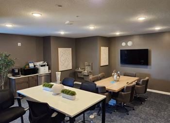 a conference room with tables and chairs and a tv at Bella Rose Apartments, Hudson, WI