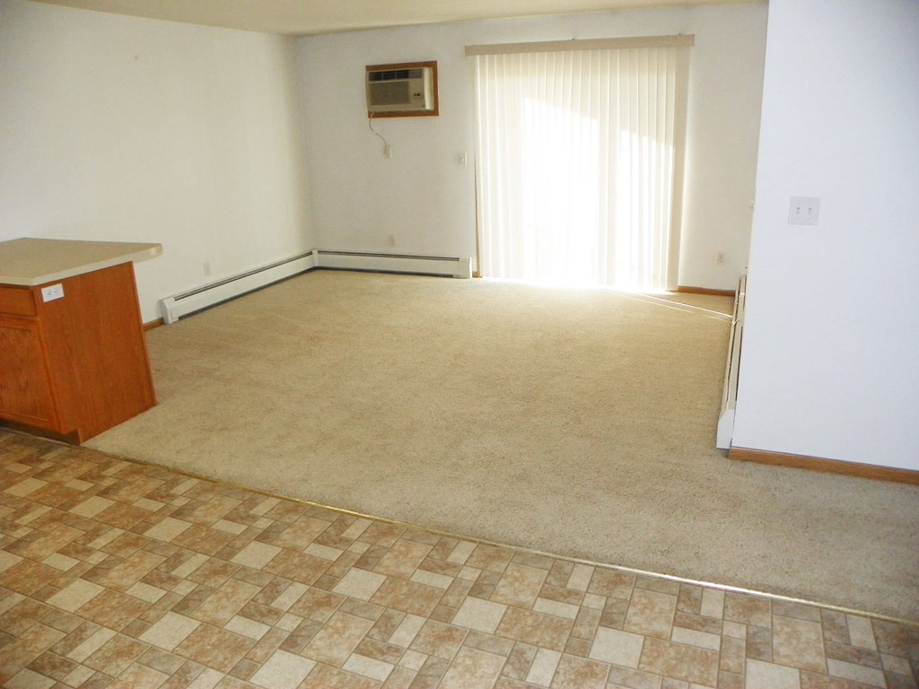 A room with a checkered floor and a window with curtains.
