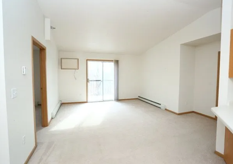 Spacious living room with balcony access at Olive Place Apartments, West Fargo, ND 58078