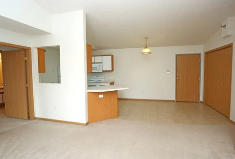 Open concept living area with kitchen breakfast bar at Olive Place Apartments, West Fargo, 58078