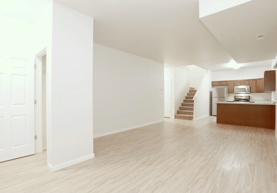A spacious room with wooden floors and white walls.