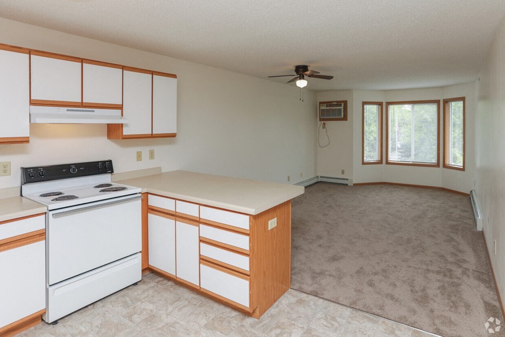 an empty kitchen with white appliances and white cabinets