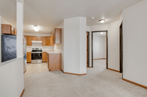 A kitchen area with a refrigerator, oven, and cabinets.