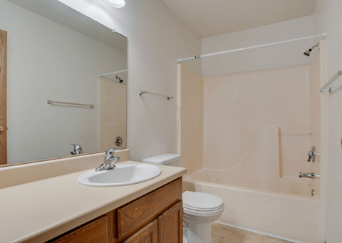 A bathroom with a sink, toilet, and bathtub.
