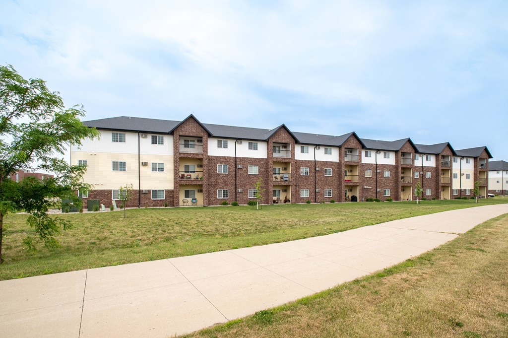 a sidewalk leading to a row of apartment buildings