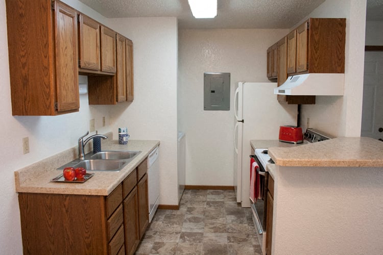 a kitchen with wooden cabinets and a sink and a refrigerator