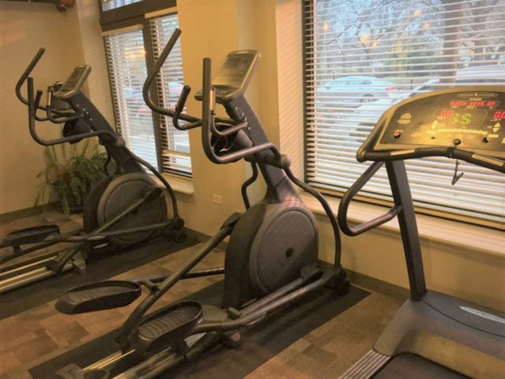 a home gym with exercise equipment in a corner of a room