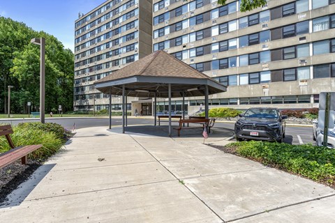 a city park with a gazebo in front of a large building