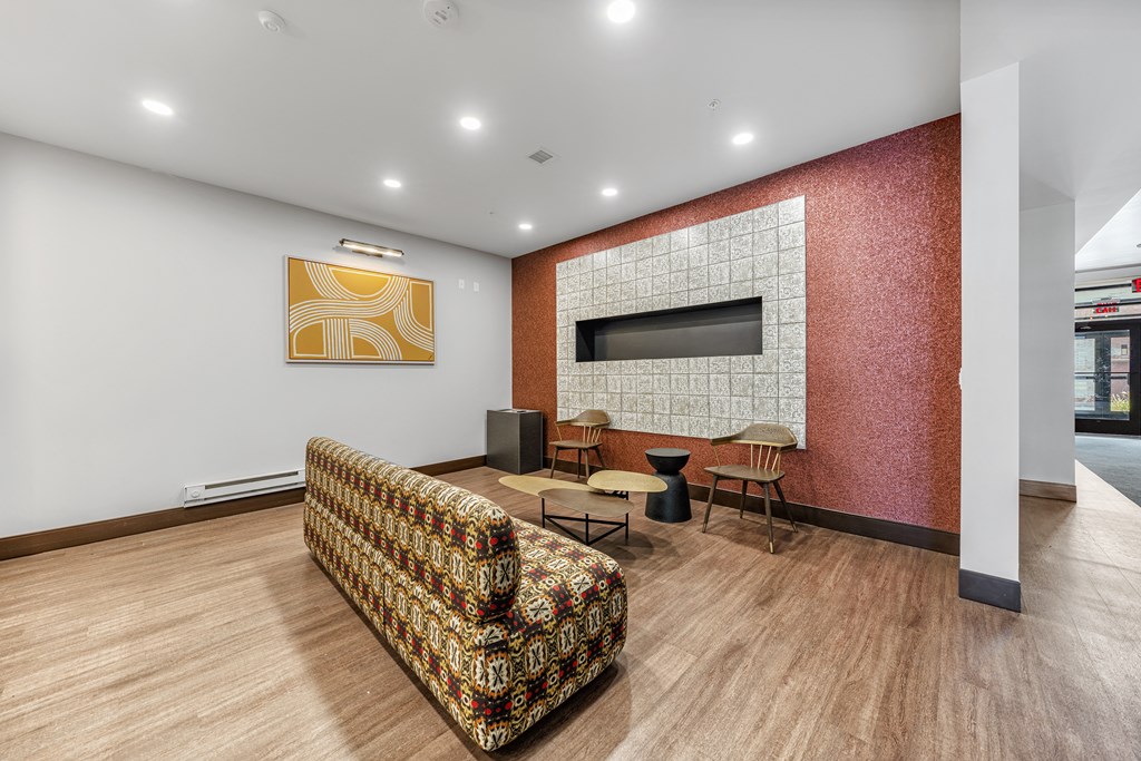a living room with a couch and a television on a brick wall