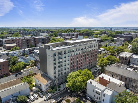 an aerial view of a large building in a city with other buildings and trees
