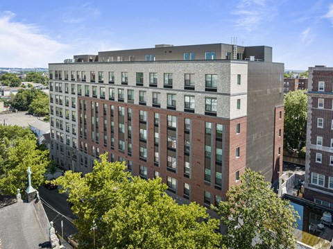 an aerial view of a tall brick building with trees