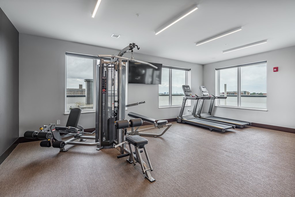 a gym with treadmills and other exercise equipment and windows