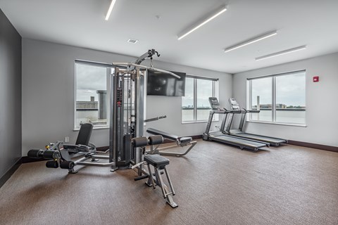 a gym with treadmills and other exercise equipment and windows