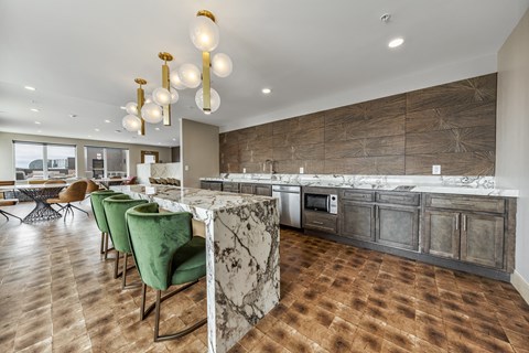 a large kitchen with marble counter tops and green chairs