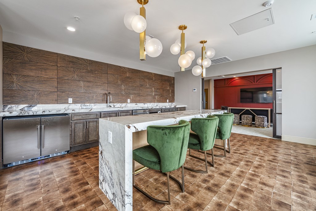 a large kitchen with marble counter tops and green chairs